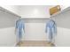 Bright walk-in closet with organized shelving, hanging rods, and matching blue robes at 27288 N 74Th Ln, Peoria, AZ 85383