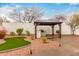 Inviting backyard with a covered grill and pergola, surrounded by decorative rock and artificial turf at 28617 N 50Th Pl, Cave Creek, AZ 85331