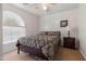 Bright bedroom with a ceiling fan, arched window, and a comfortable queen-sized bed at 31446 N Candlewood Dr, San Tan Valley, AZ 85143