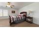 Bedroom with a ceiling fan, wooden sleigh bed, and neutral carpeting at 31446 N Candlewood Dr, San Tan Valley, AZ 85143