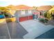 Exterior elevation showcasing a gray home with a red tile roof, three-car garage, and landscaped yard at 31446 N Candlewood Dr, San Tan Valley, AZ 85143