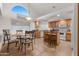 Bright kitchen with island, breakfast nook, tile floors, arched window, and plenty of cabinet space at 31446 N Candlewood Dr, San Tan Valley, AZ 85143