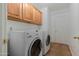 Convenient laundry room equipped with washer, dryer, and cabinets, offering practicality and storage at 31446 N Candlewood Dr, San Tan Valley, AZ 85143