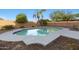 A tranquil pool with palm trees and lush plants offers a serene backyard escape at 31446 N Candlewood Dr, San Tan Valley, AZ 85143