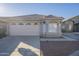 Tan single story home featuring a two car garage, bay window, and landscaped front yard at 3313 E Waltann Ln, Phoenix, AZ 85032