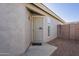 Beige home featuring a metal security screen door and a concrete walkway leading to a well-lit entryway at 3313 E Waltann Ln, Phoenix, AZ 85032