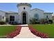 Charming home featuring a turret entry, beautiful landscaping, and a brick walkway lined with vibrant pink flowers at 3675 E Strawberry Dr, Gilbert, AZ 85298