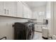 This spacious laundry room features a washer and dryer, white cabinets and marble flooring at 3675 E Strawberry Dr, Gilbert, AZ 85298