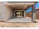 A covered back patio with concrete floors and sliding glass doors provides a seamless indoor-outdoor experience at 40531 W Michaels Dr, Maricopa, AZ 85138