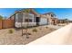 Charming single story home with gray exterior, manicured gravel landscaping, a two-car garage and brick driveway at 40531 W Michaels Dr, Maricopa, AZ 85138
