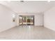 Bright and airy living room with large sliding glass doors and neutral tile flooring at 40531 W Michaels Dr, Maricopa, AZ 85138