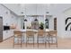 Modern kitchen with stainless steel appliances, large center island, and pendant lighting at 4302 E Marion Way, Phoenix, AZ 85018