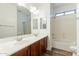 Bathroom featuring double sink vanity, a large mirror and a shower-tub combo with a window at 44383 W Windrose Dr, Maricopa, AZ 85138