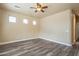 Bright bedroom features a ceiling fan, wood-look flooring, and ample lighting at 44383 W Windrose Dr, Maricopa, AZ 85138