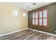 Bedroom with wood-look flooring and shuttered windows at 44383 W Windrose Dr, Maricopa, AZ 85138