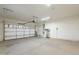 Spacious garage with concrete floor, white walls and a white door, offering space for parking and storage at 44383 W Windrose Dr, Maricopa, AZ 85138