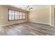 Spacious living room featuring light walls, wood floors, and plantation shutters at 44383 W Windrose Dr, Maricopa, AZ 85138