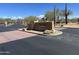 Elegant community entrance with desert landscaping and stone sign reading 