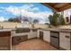 Outdoor kitchen with built-in BBQ grill and mini fridge at 5658 E Fairbrook St, Mesa, AZ 85205