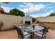 A spacious patio with a glass table and an outdoor fireplace, perfect for entertaining at 5658 E Fairbrook St, Mesa, AZ 85205