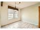 Bright dining area featuring tile floors, a decorative light fixture, and a large window with views of the outdoors at 6198 W Wikieup Ln, Glendale, AZ 85308