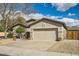 Home's exterior features an attached two-car garage and low-maintenance desert landscaping at 6198 W Wikieup Ln, Glendale, AZ 85308