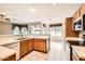 Open kitchen with tile flooring, white appliances, wood cabinets, and a view to the breakfast nook at 6198 W Wikieup Ln, Glendale, AZ 85308