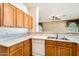 Kitchen featuring white countertops, oak cabinets, a double sink, and a white dishwasher at 6198 W Wikieup Ln, Glendale, AZ 85308