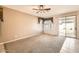 Spacious living room with carpeting, neutral walls, and a sliding glass door leading to outdoor living spaces at 6198 W Wikieup Ln, Glendale, AZ 85308