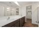 Bathroom featuring double sinks, vanity with wooden cabinets, and a glass enclosed shower at 634 W Pintail Dr, Casa Grande, AZ 85122