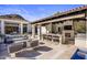 Gorgeous outdoor kitchen featuring a bar with stools, a cozy fireplace, and a sparkling pool at 6650 N Hillside Dr, Paradise Valley, AZ 85253