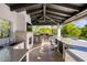 Outdoor kitchen area featuring stainless steel appliances, a bar, and a view of the pool and landscaping at 6650 N Hillside Dr, Paradise Valley, AZ 85253