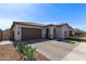 Inviting single-story home with a desert landscape, paver driveway, and a two-car garage at 6931 W Spur Dr, Peoria, AZ 85383