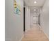 Bright hallway with wood-style tile flooring and decorative wall art, leading to various rooms in the home at 6931 W Spur Dr, Peoria, AZ 85383