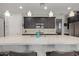 Well-lit kitchen featuring an expansive island with bar stools and stylish lighting at 6931 W Spur Dr, Peoria, AZ 85383