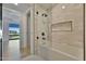 Contemporary bathroom featuring a shower-tub combo with glass partition, light tile, and black hardware at 7161 E Rancho Vista Dr # 6009, Scottsdale, AZ 85251