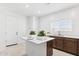 Kitchen island with white countertops, stainless steel sink, brown cabinets and white walls at 7378 W Whitehorn Trl, Peoria, AZ 85383