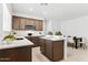 Bright kitchen features an island, stainless steel microwave, brown cabinets and white countertops at 7378 W Whitehorn Trl, Peoria, AZ 85383