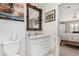 Bathroom vanity with ornate mirror next to a toilet and a doorway to the bedroom at 7515 N 185Th Ave, Waddell, AZ 85355