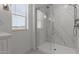 Bright bathroom features a glass enclosed shower, and a view out the window for natural light at 7988 W Griswold Rd, Peoria, AZ 85345