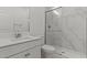 Modern bathroom featuring marble shower, white vanity, and gold hardware at 7988 W Griswold Rd, Peoria, AZ 85345