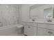 A clean, bright bathroom featuring a marble accent wall, with double sinks and modern fixtures at 7988 W Griswold Rd, Peoria, AZ 85345