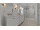 A well-lit bathroom features dual sinks, modern fixtures, and a large glass shower with marble surround at 7988 W Griswold Rd, Peoria, AZ 85345