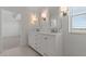 Bright bathroom showcasing a double sink vanity, stylish mirrors with sconces, and bright natural light at 7988 W Griswold Rd, Peoria, AZ 85345