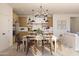 Open dining area with a modern chandelier, wood table, and seamless transition to the kitchen at 7988 W Griswold Rd, Peoria, AZ 85345