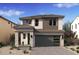 Modern two-story home featuring a gray garage door and a well-manicured desert landscape at 7988 W Griswold Rd, Peoria, AZ 85345