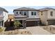 Charming two-story home featuring stone accents and a modern brown garage door, complemented by desert landscaping at 7988 W Griswold Rd, Peoria, AZ 85345