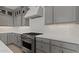 Modern kitchen featuring white subway tile backsplash, gray cabinets, stainless steel range, and quartz countertops at 7988 W Griswold Rd, Peoria, AZ 85345