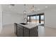 Modern kitchen island featuring a sink and a view of the outdoor space through sliding glass doors at 7988 W Griswold Rd, Peoria, AZ 85345