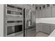 Modern kitchen featuring stainless steel refrigerator, built-in oven, and gray cabinets with subway tile backsplash at 7988 W Griswold Rd, Peoria, AZ 85345